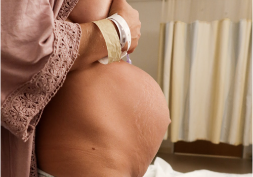 A woman shows her pregnant belly A woman shows her pregnant belly